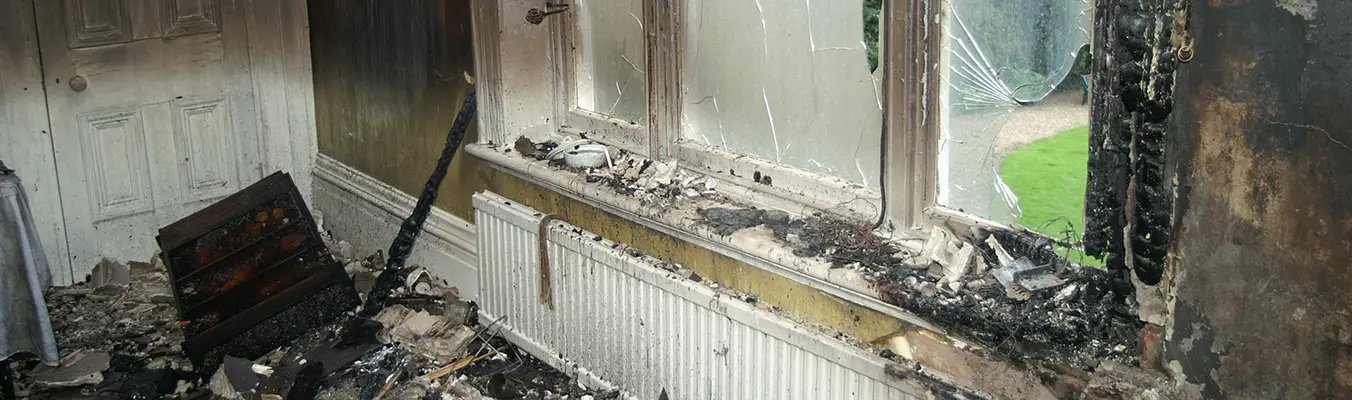 Water damage and fire damage restoration project by JTB Construction in Charleston SC showing damaged window frames, charred walls, and destroyed interior materials requiring professional restoration